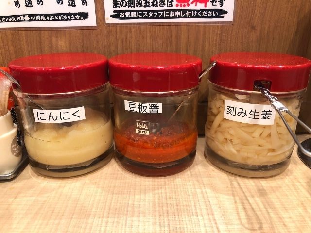 テーブルの上にあるにんにく、豆板醤、刻みショウガ